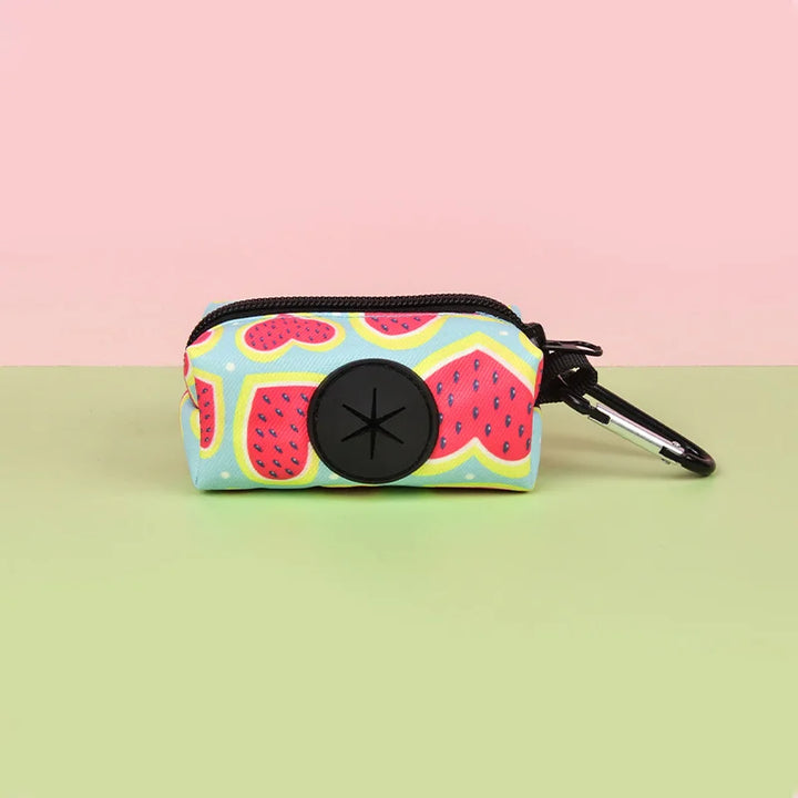 Small Dog Poop Bag Holder with fruit pattern and carabiner on a pink and green gradient background