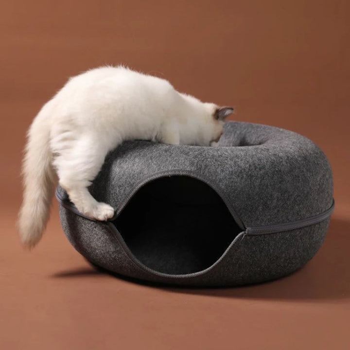 White cat climbing into a gray Cat tunnel bed