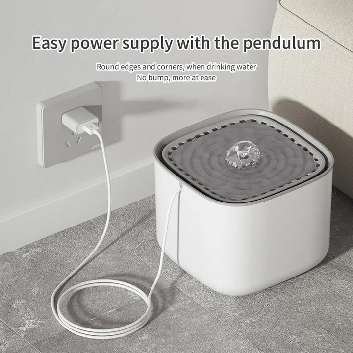 Cat water fountain with USB power supply cord plugged into a wall outlet.