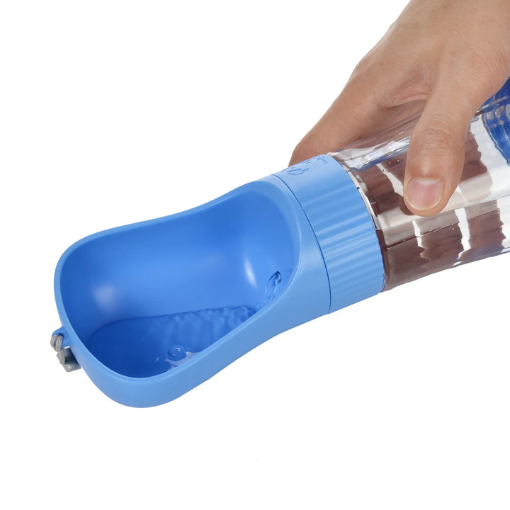 Blue portable dog water and food bottle held by a hand 
